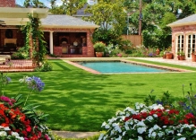 Modern-shaped-swimmng-pool-with-landscaping-arbor-patio-cove-and-outdoor-ktichen