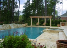 mediterranean-pool-with-spa-that-spills-over-into-swimming-pool-water-feature-along-backside-of-swimming-poo-with-a-circular-arbor