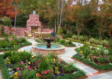 deck with fireplace, fountain and decorative landscaping